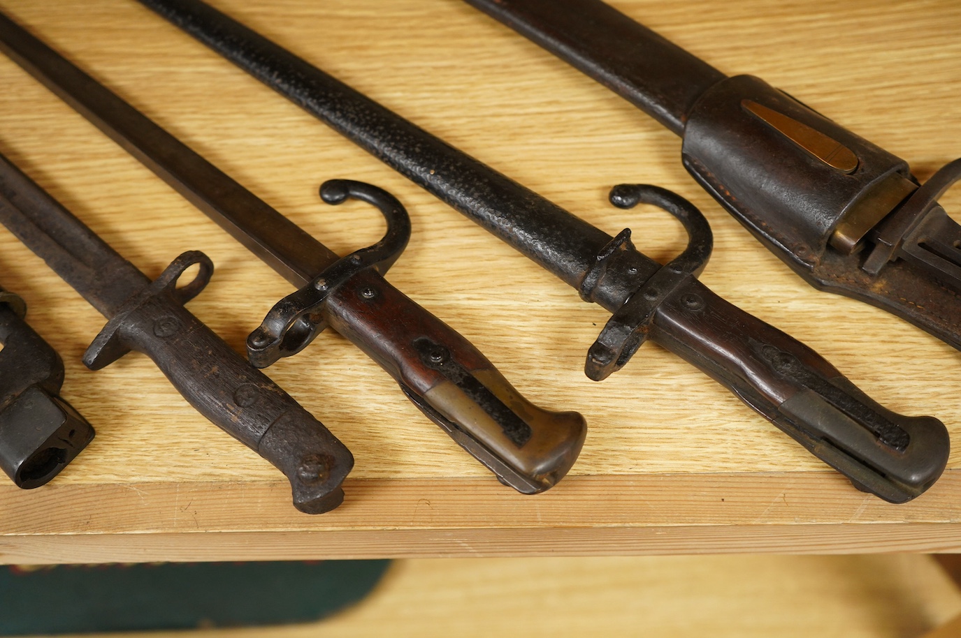 Seven bayonets; a speculative 20th century English bayonet of unknown type with broad arrow and other English type markings, together with a German butcher bayonet in scabbard (grips missing), a Gras bayonet and scabbard